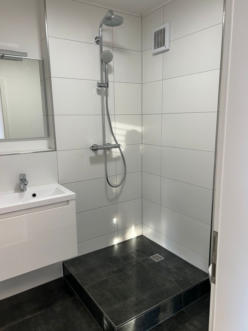 Weiße Dusche mit schwarzer Steinablage
