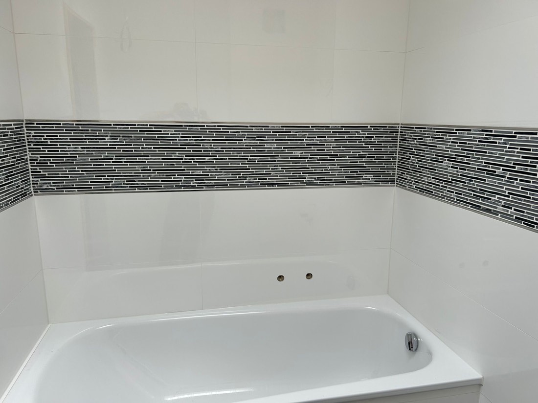 Badewanne mit Mosaik-Bordüre